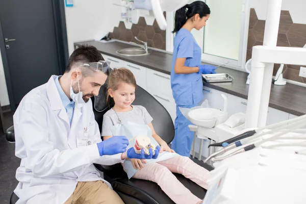 Pequena Menina Bonito Sentado Poltrona Olhando Para Dentes Falsos Realizada — Fotografia de Stock