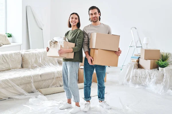 Young Cheerful Couple Casualwear Holding Packed Boxes Household Stuff While — Stock Photo, Image