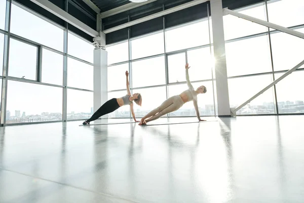 Two Pretty Young Sportswomen Tracksuits Keeping Arms Stretched While Doing — Stock Photo, Image