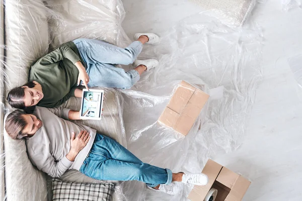 Visão Geral Jovem Casal Afetuoso Com Tablet Sentado Novo Sofá — Fotografia de Stock