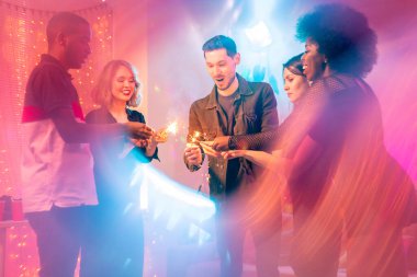 Kültürler arası beş genç arkadaş toplanmış ve merkezde parıldayan bengal ışıkları tutarak ev partisinin tadını çıkarıyorlar.