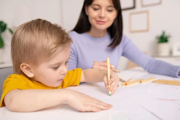 Gros Plan Mignon Garçon Concentré Assis Table Utilisant Des Crayons — Photo