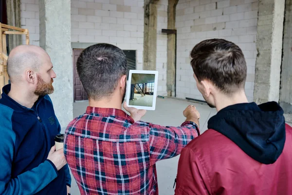Dos Construtores Contemporâneos Com Tablet Mostrando Seus Colegas Onde Eles — Fotografia de Stock