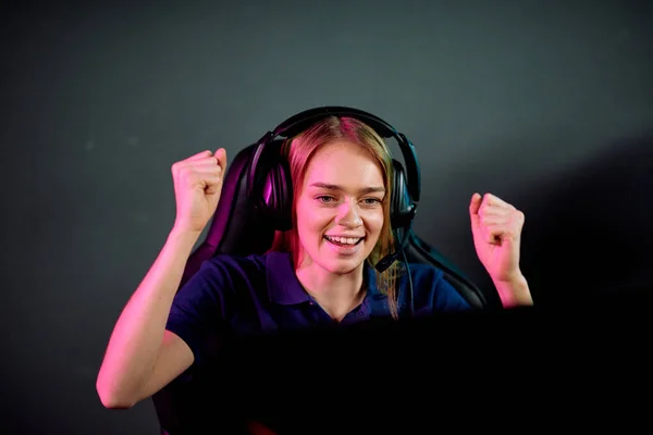 快乐的年轻女子戴着耳机 一边做着肯定的手势 一边庆祝在电子游戏比赛中获胜 — 图库照片
