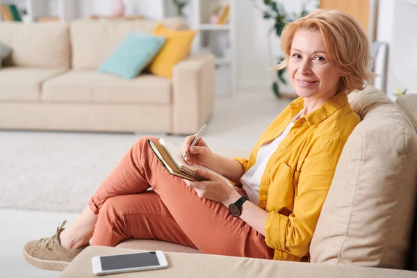 Pretty Mature Businesswoman Casualwear Sitting Couch Living Room Making Notes — Stock Photo, Image