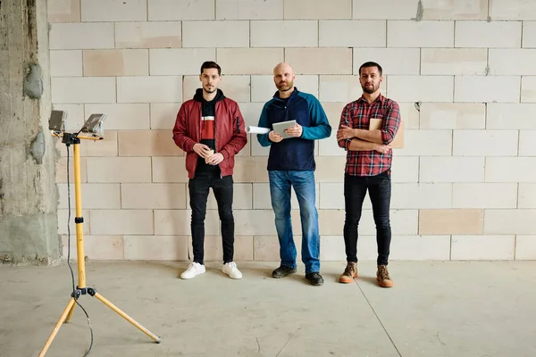 Tres Jóvenes Ingenieros Constructores Masculinos Ropa Trabajo Pie Línea Largo — Foto de Stock