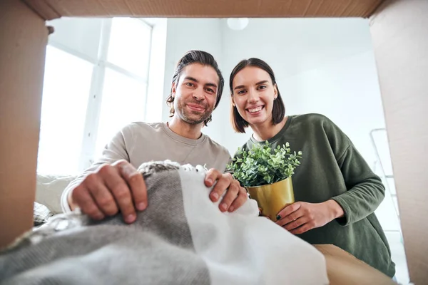 Jovem Marido Mulher Alegre Casualwear Olhando Para Você Enquanto Desembalando — Fotografia de Stock