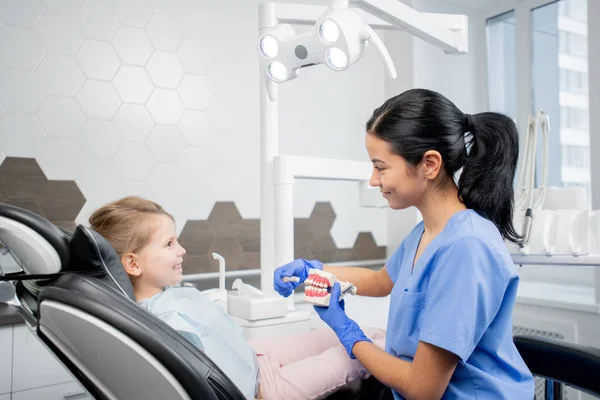 Mooie Jonge Tandarts Assistent Blauw Uniform Tonen Weinig Patiënt Fauteuil — Stockfoto