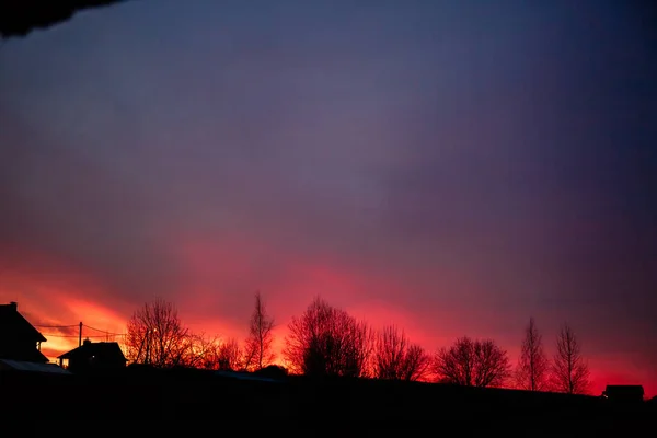 Puesta de sol muy hermosa en el pueblo. El cielo rojo arde . — Foto de Stock