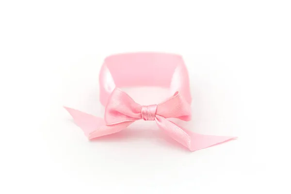 Un braccialetto di prua rosa si trovano su uno sfondo bianco. Simbolo dell'identità sessuale della ragazza . — Foto Stock