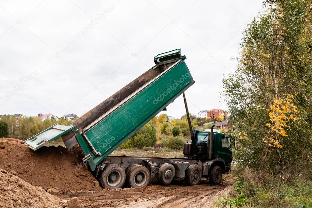 A large 70-ton dump truck brought sand to a new construction site to add land