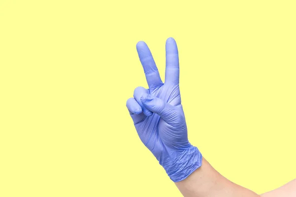 Male hand on yellow background showing the symbol of victory or the number two or sexual insult — Stock Photo, Image