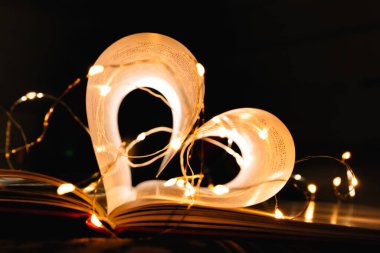 Parlak çelenk ışıklarıyla süslenmiş kalp şeklinde çarşafları olan sanat kitabı. Aşkın sembolü.