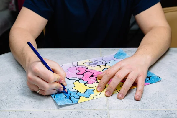 Hombre dibuja un cuadro imaginario abstracto con un lápiz y lo decora con diferentes colores, una prueba psicológica —  Fotos de Stock