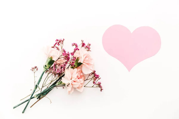 Buquê de flores no fundo branco com papel rosa símbolo do coração do amor — Fotografia de Stock