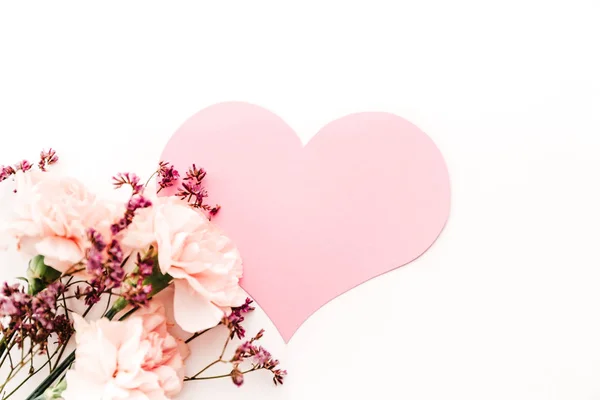 Buquê de flores no fundo branco com papel rosa símbolo do coração do amor — Fotografia de Stock