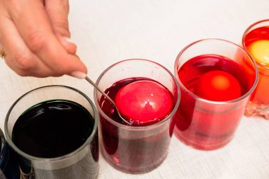 Paskalya yumurtalarını gözlüklerdeki boyayla boyamak. Tatil için ev dekorasyonu. Pembe bir yumurta al. Yakın plan.