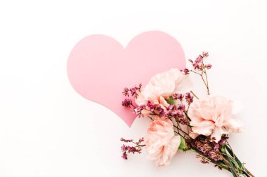 Beyaz arka planda çiçek demeti pembe kağıt kalp sembolü aşk, minimalizm