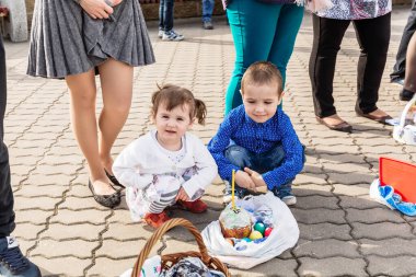Beryoza, Belarus - 27 Nisan 2019: Çocuklar kiliseye geldiler ve rahibin Paskalya pastaları ve renkli yumurtalarla onları serpmesini bekliyorlar. Hıristiyan dini geleneği.