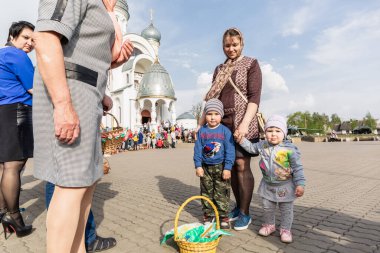 Beryoza, Belarus - 27 Nisan 2019: Çocuklar kiliseye geldiler ve rahibin Paskalya pastaları ve renkli yumurtalarla onları serpmesini bekliyorlar. Hıristiyan dini geleneği.