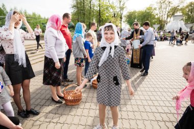 Beryoza, Belarus - 27 Nisan 2019: Rahip, Hristiyan dini geleneklerine göre, inançlıları ve Paskalya pastalarını, yumurta ve mumları kilisenin yakınında kutsal suyla boyadı..