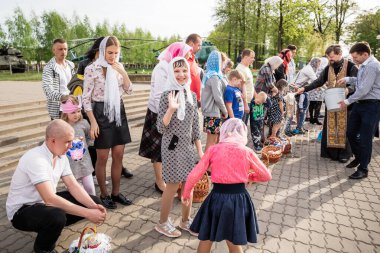 Beryoza, Belarus - 27 Nisan 2019: Rahip, Hristiyan dini geleneklerine göre, inançlıları ve Paskalya pastalarını, yumurta ve mumları kilisenin yakınında kutsal suyla boyadı..