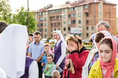 Beryoza, Belarus - 27 Nisan 2019: Rahip, Hristiyan dini geleneklerine göre, inançlıları ve Paskalya pastalarını, yumurta ve mumları kilisenin yakınında kutsal suyla boyadı..