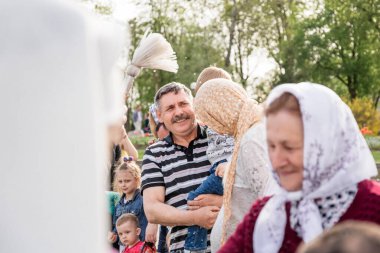 Beryoza, Belarus - 27 Nisan 2019: Rahip, Hristiyan dini geleneklerine göre, inançlıları ve Paskalya pastalarını, yumurta ve mumları kilisenin yakınında kutsal suyla boyadı..