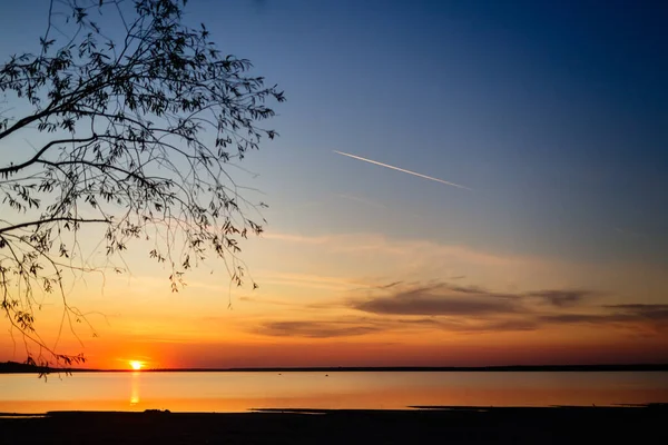 Radenin Dalları Arasından Gün Batımını Göl Üzerinde Parlak Bir Günbatımında — Stok fotoğraf