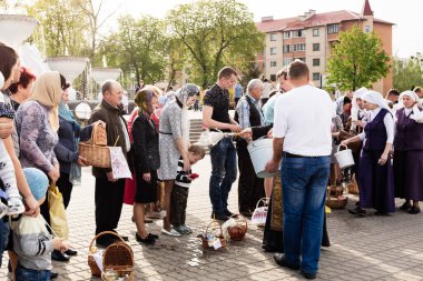 Beryoza, Belarus - 27 Nisan 2019: Rahip, Hristiyan dini geleneklerine göre, inançlıları ve Paskalya pastalarını, yumurta ve mumları kilisenin yakınında kutsal suyla boyadı..