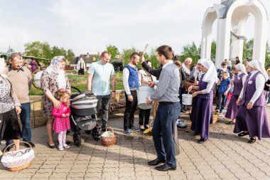 Beryoza, Belarus - 27 Nisan 2019: Rahip, Hristiyan dini geleneklerine göre, inançlıları ve Paskalya pastalarını, yumurta ve mumları kilisenin yakınında kutsal suyla boyadı..