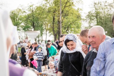 Beryoza, Belarus - 27 Nisan 2019: Rahip, Hristiyan dini geleneklerine göre, inançlıları ve Paskalya pastalarını, yumurta ve mumları kilisenin yakınında kutsal suyla boyadı..
