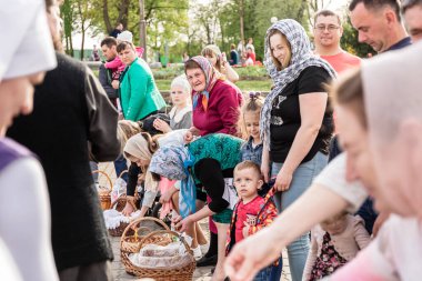 Beryoza, Belarus - 27 Nisan 2019: Rahip, Hristiyan dini geleneklerine göre, inançlıları ve Paskalya pastalarını, yumurta ve mumları kilisenin yakınında kutsal suyla boyadı..