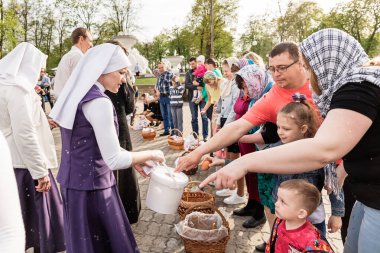Beryoza, Belarus - 27 Nisan 2019: Rahip, Hristiyan dini geleneklerine göre, inançlıları ve Paskalya pastalarını, yumurta ve mumları kilisenin yakınında kutsal suyla boyadı..