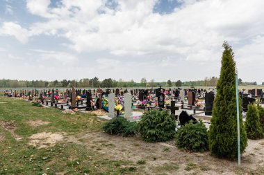 Taze ve eski mezarları olan bir mezarlık. Yeni defin için bölge. Bulutlu.