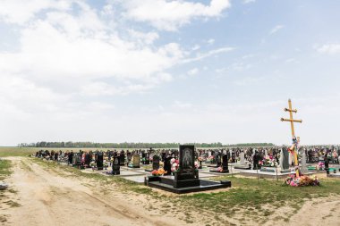 Taze ve eski mezarları olan bir mezarlık. Yeni defin için bölge. Bulutlu.