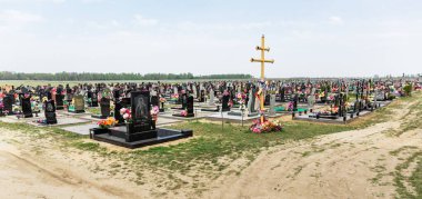 Taze ve eski mezarları olan bir mezarlık. Yeni defin için bölge. Bulutlu.