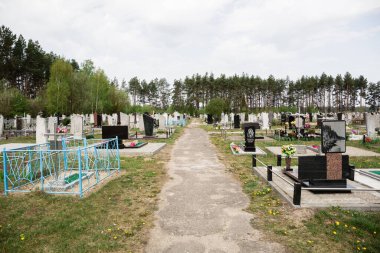 Taze ve eski mezarları olan bir mezarlık. Yeni defin için bölge. Bulutlu.