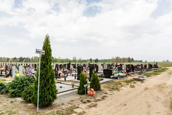 Taze ve eski mezarları olan bir mezarlık. Yeni defin için bölge. Bulutlu.