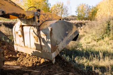 Büyük sarı tekerlek yükleyici yeni bir bina için bir parça arazi hizalıyor. Arazinin açık artırma için hazırlanması. Manzarayı düzleştirip inşaat için kum ekliyorum. Pankart Duvar Kağıdı.