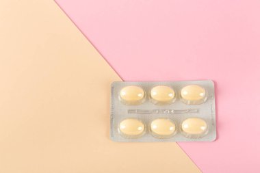 Pembe arka plandaki tabletler, vajinal antibakteriyel kapsüller yakın plan.