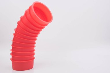 Beyaz arka planda kırmızı plastik bir boru