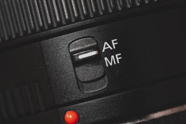 Close-up of the AF switch on the camera lens. Closeup of an autofocus switch on a camera lens. clipart