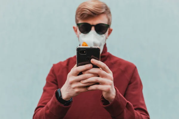 Ein Unter Quarantäne Stehender Mann Mit Schutzmaske Benutzt Ein Smartphone — Stockfoto