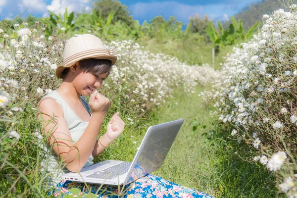 Menina usar laptop no campo crisântemo — Fotografia de Stock