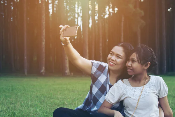 Mère et fille utilisent un téléphone intelligent . — Photo