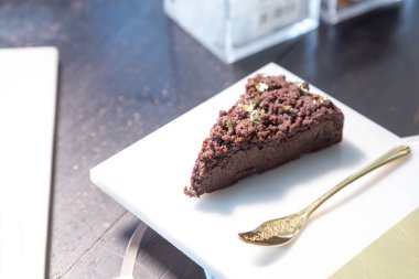 Mermer tabakta çikolatalı pasta ve restoranda altın kaşık..