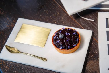 Mermer tabakta yabanmersinli turta ve fotokopi alanı olan bir restoranda altın kaşık..