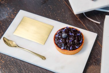 Mermer tabakta yabanmersinli turta ve fotokopi alanı olan bir restoranda altın kaşık..