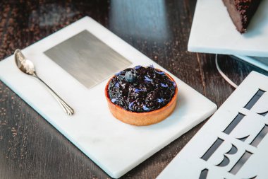 Mermer tabakta yabanmersinli turta ve fotokopi alanı olan bir restoranda altın kaşık..